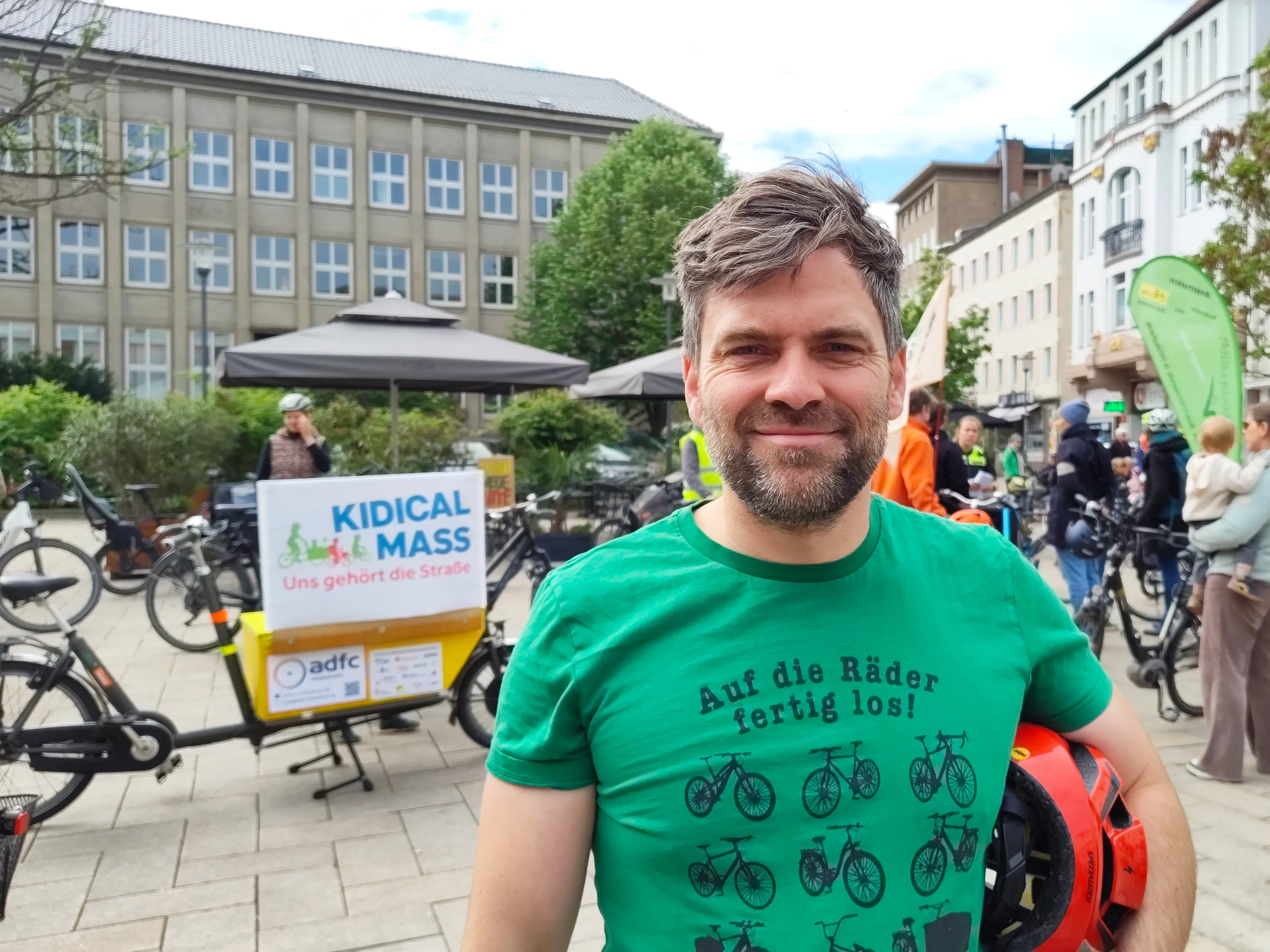 Levin Keller auf der Kidical Mass in Hildesheim, vor dem ADFC-Lastenrad mit dem Schild „Kidical Mass — Uns gehört die Straße“